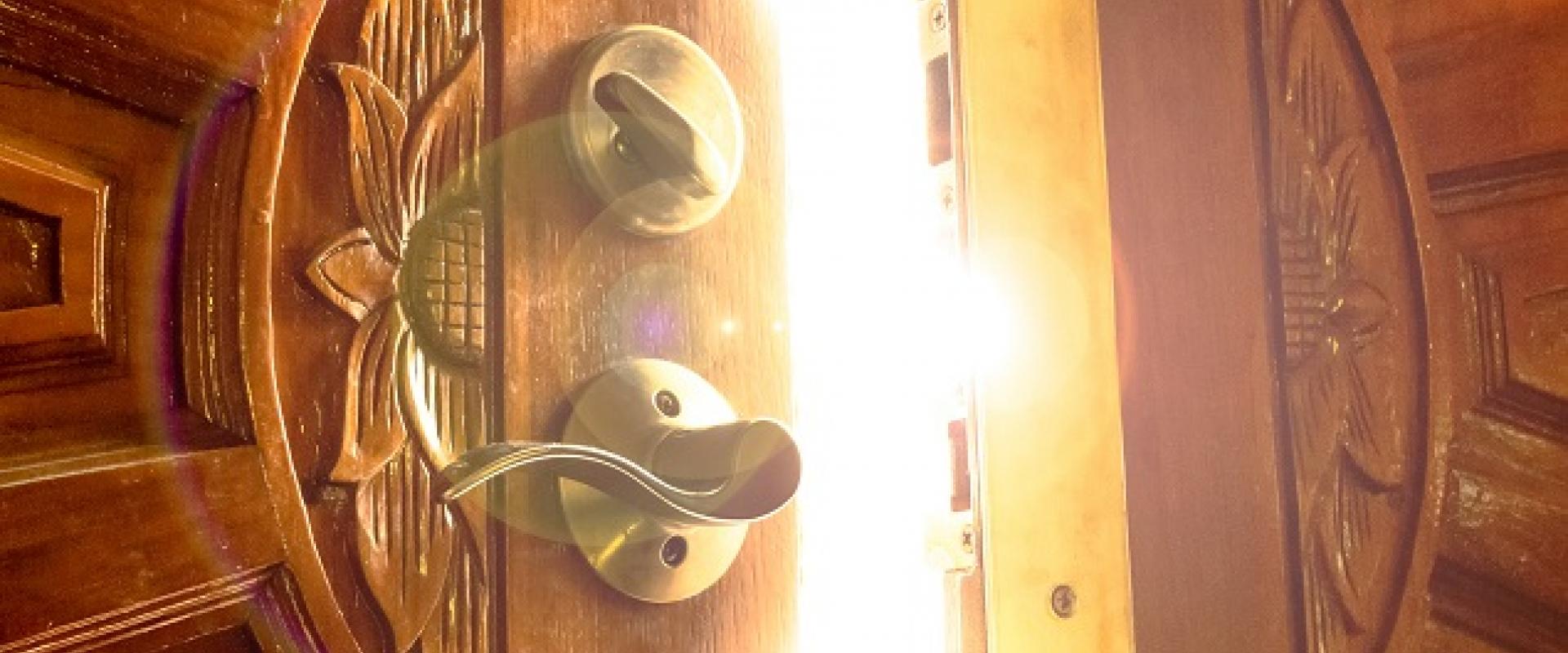 wooden doors opening with gold light coming through gap