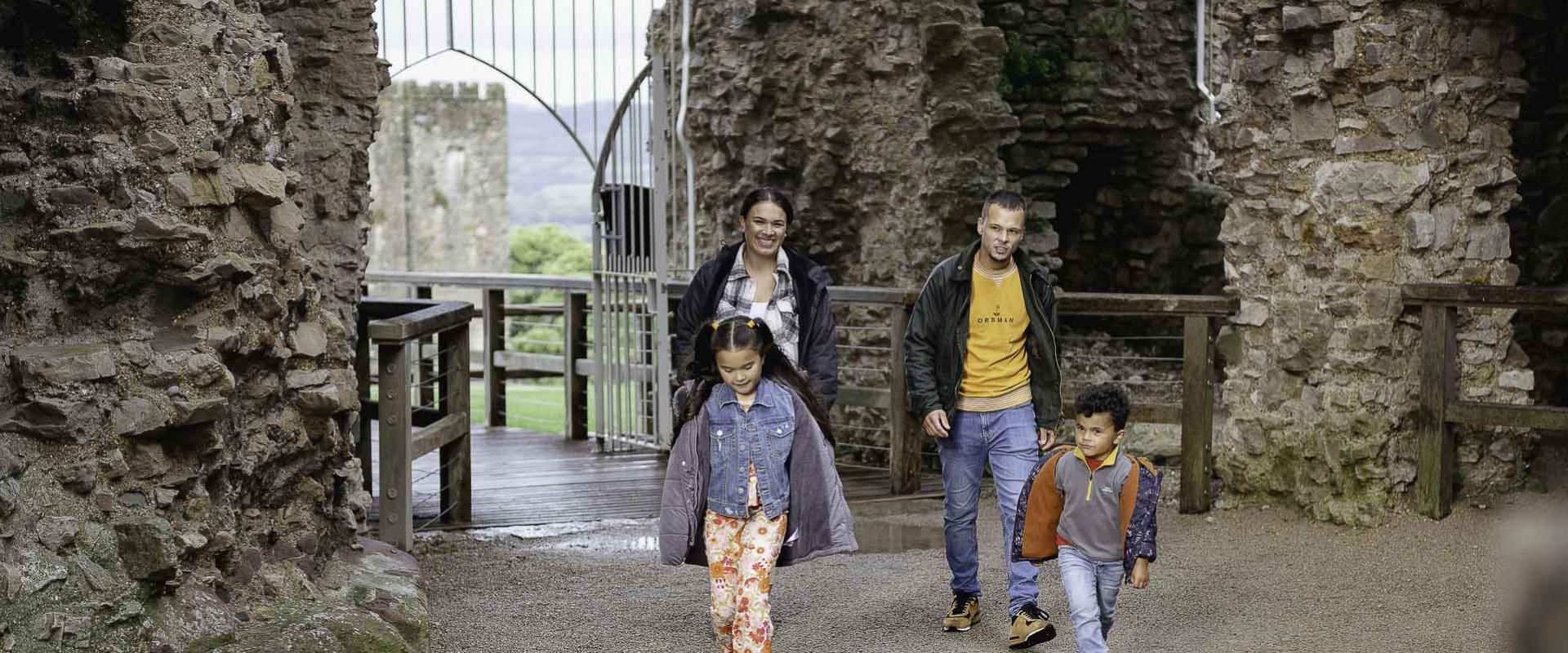 Ymwelwyr yn mynd i mewn i borthdy Castell Dinbych/Visitors entering the gatehouse of Denbigh Castle