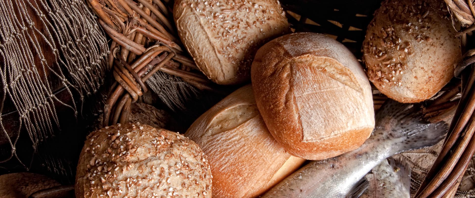 An tipped basket with bread rolls and fish 