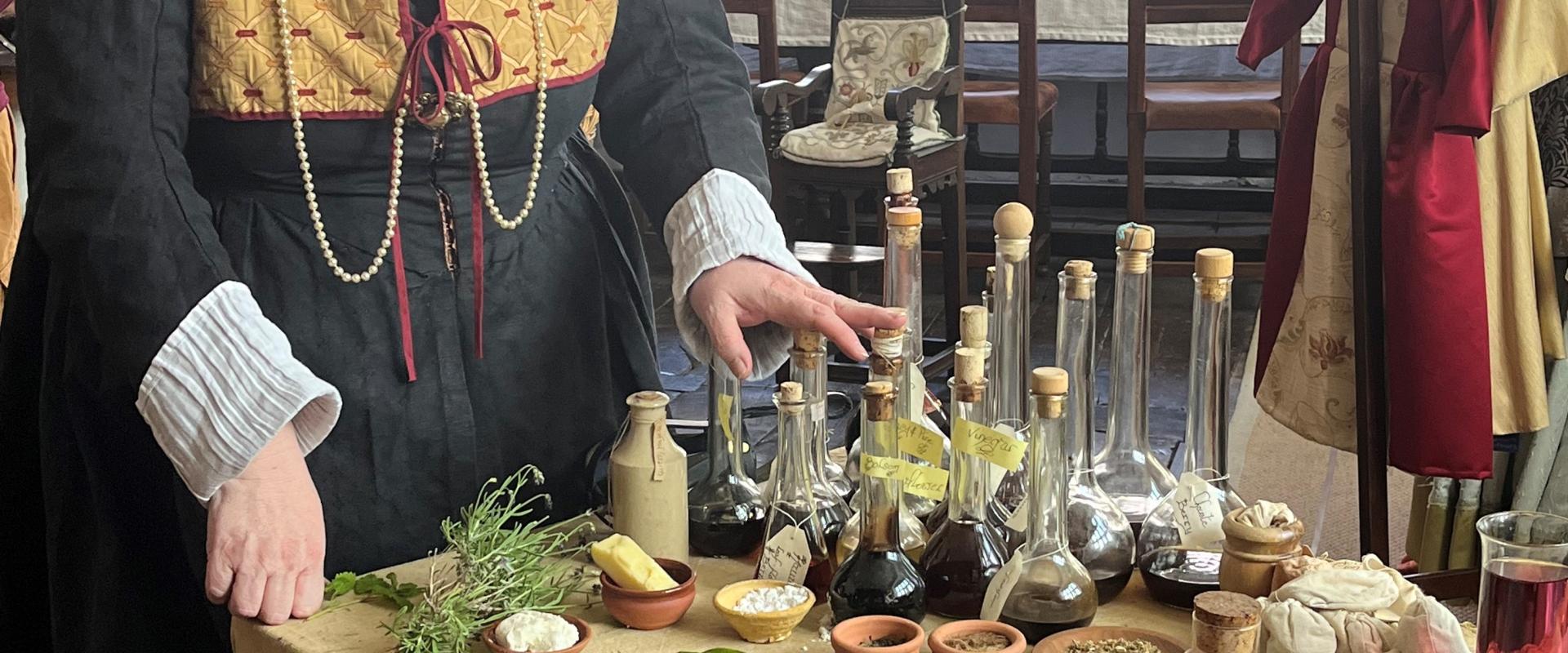 A Tudor Wise woman displaying her herbs and potions