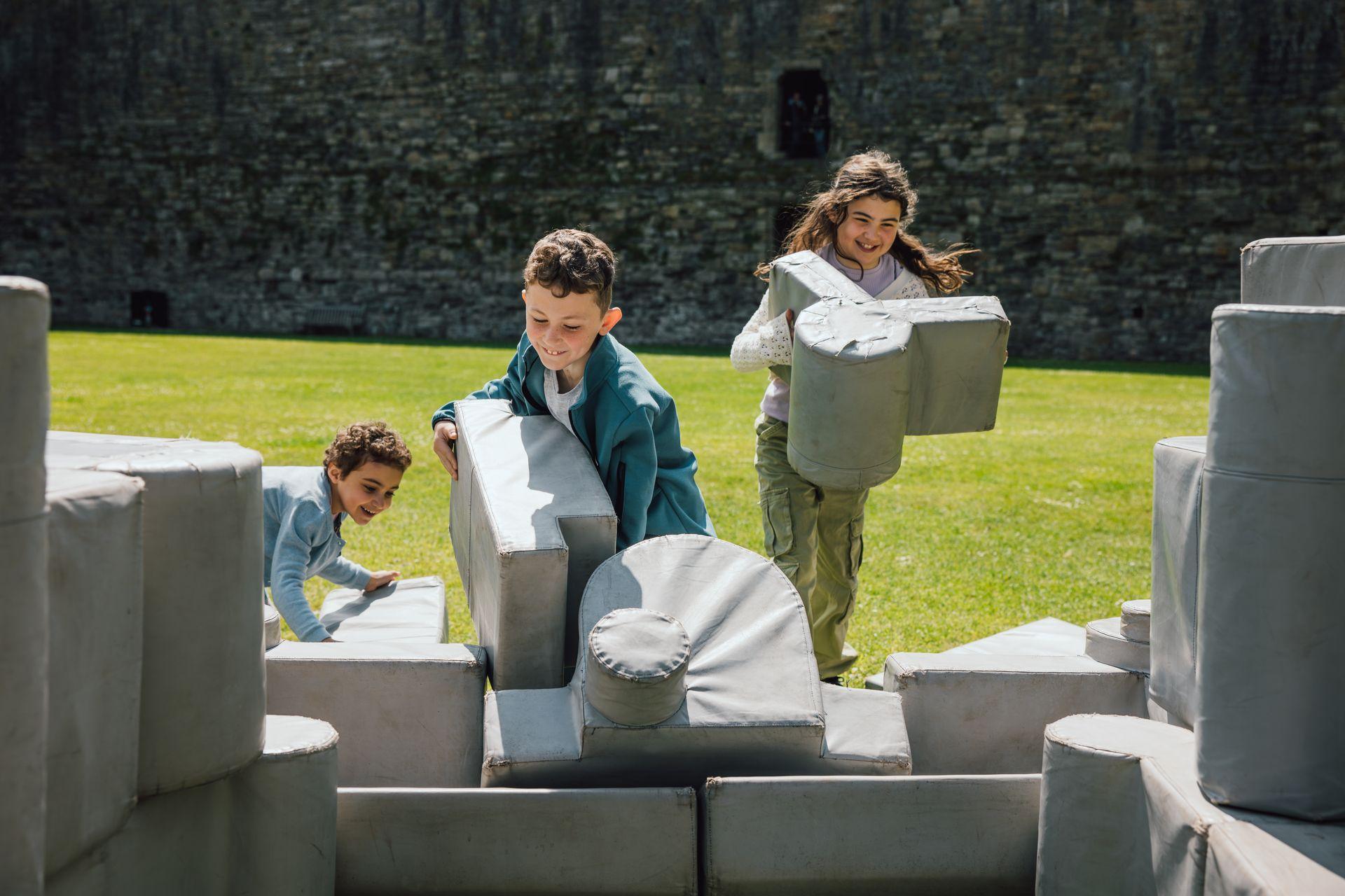 Ymwelwyr yn adeiladu atgynhyrchiad meddal o Gastell Biwmares/Visitor building a soft replica of Beaumaris Castle.